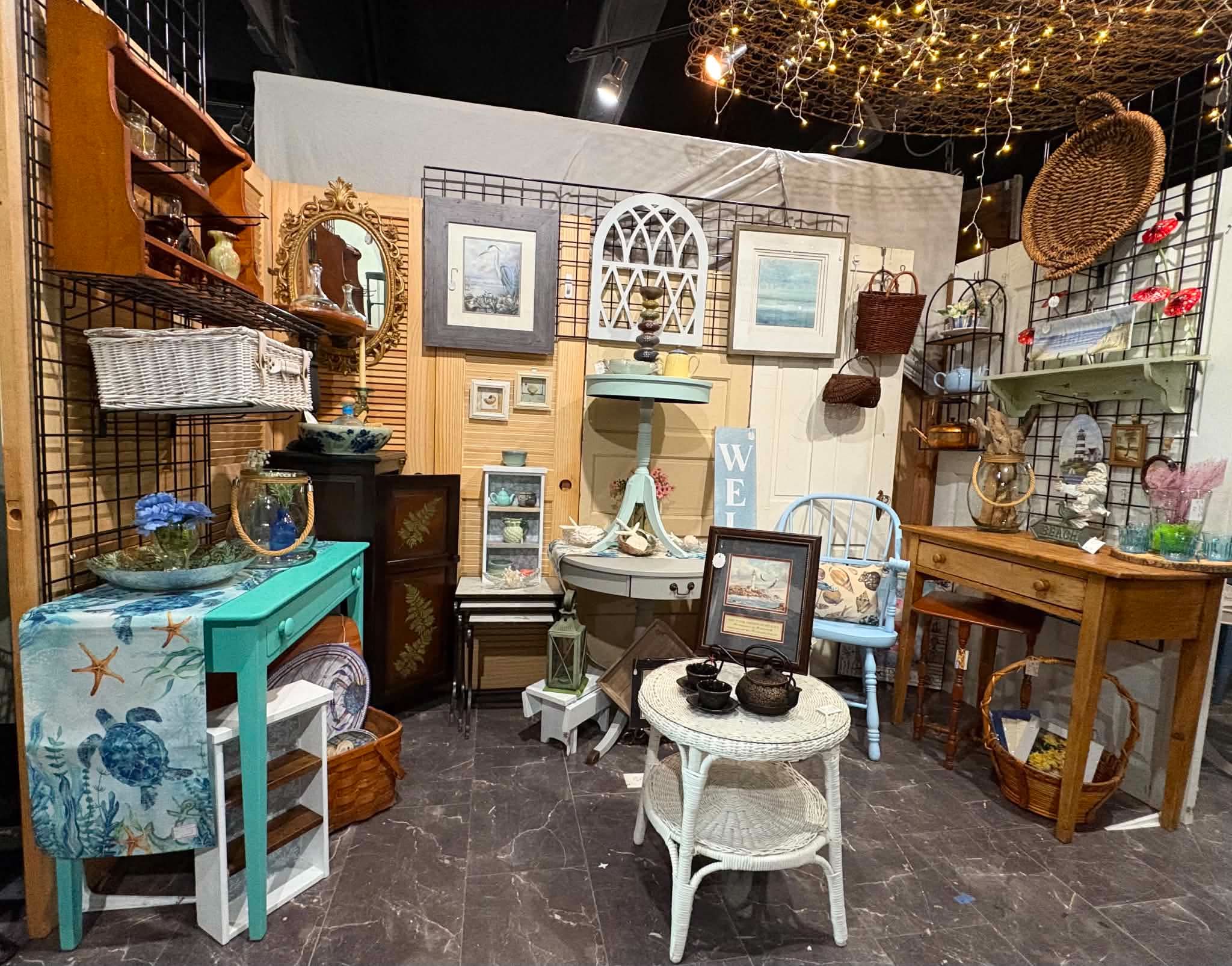 Caught My Eye booth with colorful furniture, wall art, baskets, and home accessories