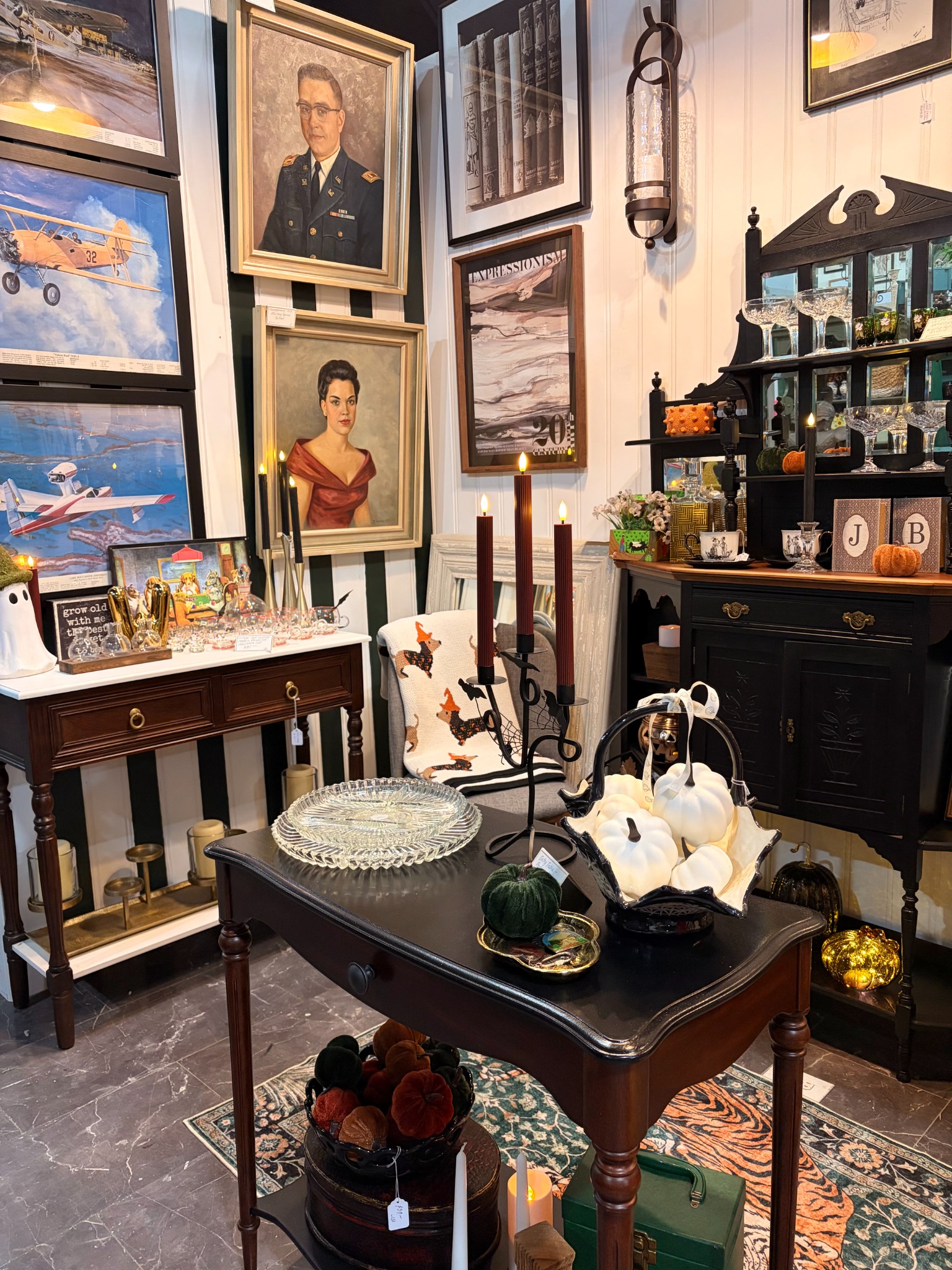 Juniper & Brass booth filled with curated vintage artwork, furniture, glassware, and seasonal décor